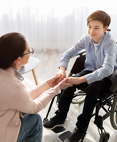 Pflegekraft von Liora reicht Kind im Rollstuhl die Hand – einfühlsame Kinderpflege zu Hause